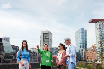 Das Bild zeigt eine Stadtführung im Medienhafen mit vier Personen