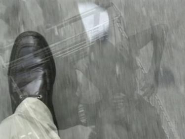 Die Draufsicht auf den schwarzen Lederschuhen des Künstler. Überblendet von spielenden schwarzen Kindern in einem Einkaufswagen